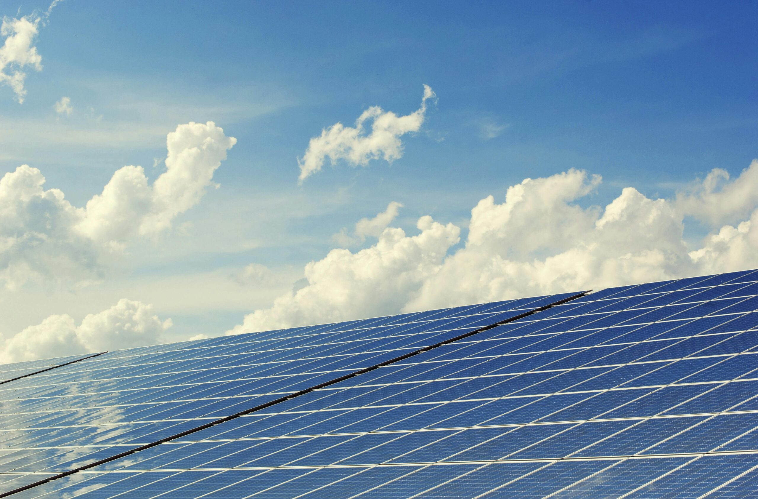 pexels-photo-356036-356036 | Архитектура Махариши Васту Sleek modern solar panels under a vibrant blue sky with clouds, symbolizing clean energy.